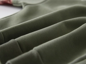 Macro shot of army green cotton fabric texture and ribbed cuff detail on boys sweatshirt