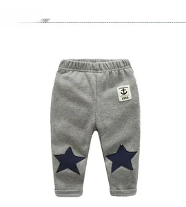 Detailed view of gray cotton joggers with blue star knee patches and anchor badge