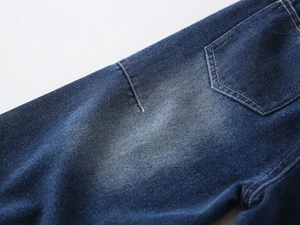 Detailed macro view of dark blue boys denim jeans showing back pocket and stitching