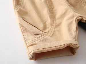 Close-up of khaki cotton twill fabric showing fine stitching and cuffed hem details