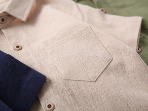 Detailed macro of textured linen-blend boy's short sleeve shirt showing pocket and buttons