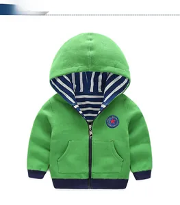 Détail du sweat à capuche vert avec doublure rayée et écusson sportif brodé sur la poitrine
