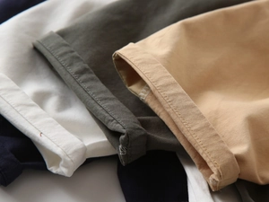 Detailed close-up of folded hems and stitching on multi-color cotton chino shorts