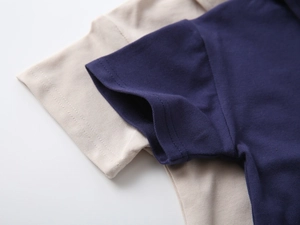 Close-up of pique cotton fabric and stitching detail on navy and beige polo shirts