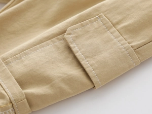 Macro shot of khaki cotton cargo shorts with detailed contrast white stitching
