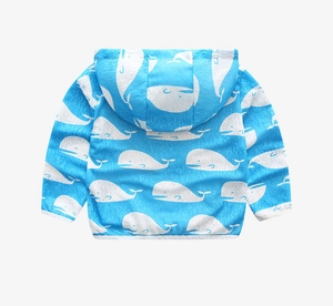 Detail of blue toddler windbreaker featuring an all-over white cartoon whale pattern