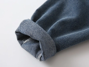Detail of cuffed hem on boys retro blue denim jeans with durable stitching