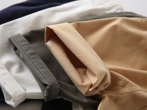 Detailed close-up of folded cotton shorts in navy, white, khaki, and olive green colors