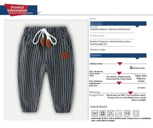 Detail of dark gray striped cotton pants for boys with drawstring and leather badge