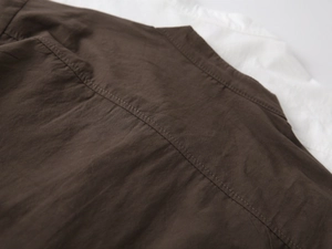 Detailed stitching on the back shoulder of a brown cotton V-neck boys shirt
