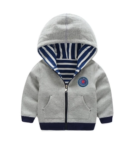 Détail du sweat à capuche gris avec doublure rayée et écusson étoile brodé
