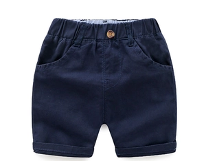 Detail of navy blue cotton shorts featuring an elastic waistband and brown decorative button