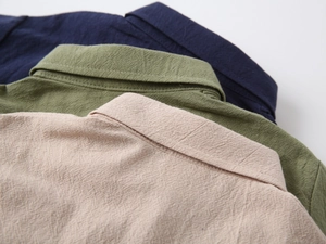 Detailed view of kids short sleeve shirt collars in navy, olive green and beige linen