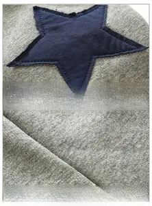 Detail of star-shaped patch and soft marl grey knit fabric on toddler joggers