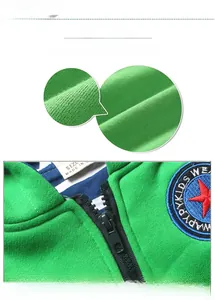 Détail de la veste verte pour enfant montrant le tissu en maille et l'étoile brodée
