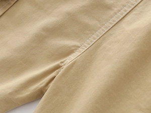 Macro shot of double-needle stitching on khaki cotton twill fabric for boys' shorts