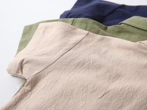 Close-up of cotton linen fabric textures in beige, olive green, and navy blue for boy sets