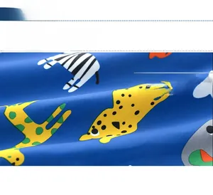Close-up of soft breathable cotton fabric with colorful cartoon zebra and giraffe prints