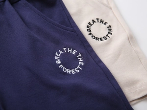 Detailed close-up of cotton knit shorts featuring the Breathe The Forest embroidery design