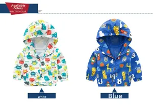 Detail of hooded kids windbreakers in white dinosaur and blue forest animal prints
