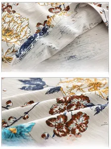 Detailed view of breathable cotton fabric with retro floral pattern and stitching for kids tee