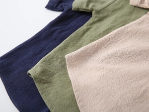 Detailed fabric texture of boy's cotton linen shirts in navy, olive green and beige