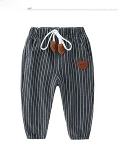 Detail of grey striped boys' trousers with elastic drawstring waist and leather patches