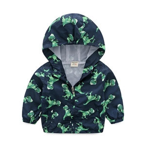 Detailed view of kids hooded windbreaker featuring green geometric dinosaur prints