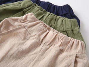 Elastic waist detail on cotton linen shorts in navy blue, olive green, and beige colors