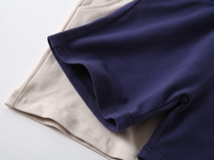 Detailed macro view of navy and beige pique knit fabric texture with neat double-needle stitching