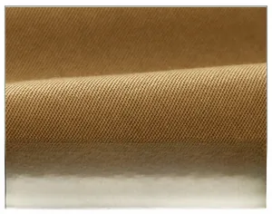 Close-up of camel brown twill fabric texture on children's summer shorts with soft weave