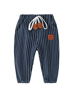 Detail of navy striped kids trousers with elastic drawstring waist and leather patch