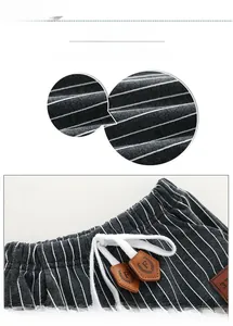 Detail of grey striped boy trousers with elastic waist and leather drawstring charm