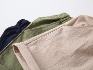 Detail of cotton linen shorts featuring textured fabric and elastic waist in three colors