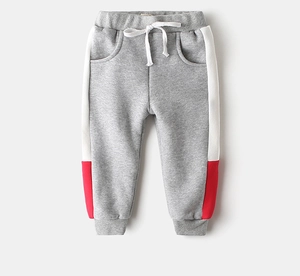 Detail of gray boys joggers featuring elastic waistband with white drawstrings and side stripes