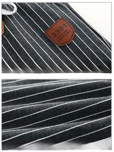 Detail of dark grey striped fabric on boy pants with drawstrings and a leather label