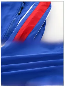 Détail de la veste bleue pour garçon avec rayures rouges et blanches et texture polyester
