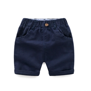 Navy blue cotton twill shorts for boys with elastic waist and rolled hems in flat lay