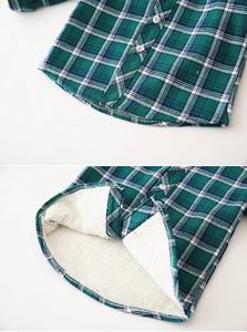Detail of boys' winter plaid shirt showing green checkered fabric and warm fleece lining