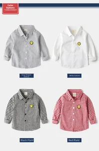 Detail of four boys' cotton shirts in stripe, white and checkered patterns with smiley patch