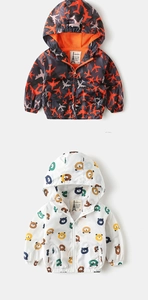 Detail of hooded kids windbreakers with airplane and bear prints featuring zip closure