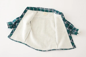 Close-up of boys' green plaid winter shirt featuring thick white sherpa fleece lining