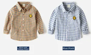 Detail of kids long sleeve plaid shirts featuring yellow smiley face patches on chest