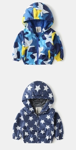 Close-up of children's hooded windbreakers featuring colorful star patterns and elastic cuffs