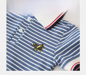 Detailed close-up of boys' striped polo shirt with yellow airplane embroidery and knit collar