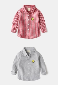 Detail view of boys' long sleeve shirts featuring red checks, grey stripes and smiley patch