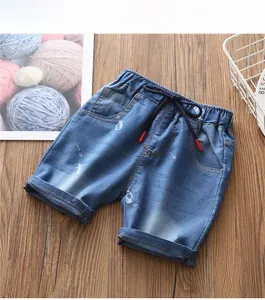 Dettaglio di pantaloncini di jeans azzurri con stampe di auto e coulisse in vita