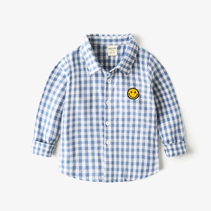 Detail of blue and white checkered shirt with yellow smiley face embroidery patch