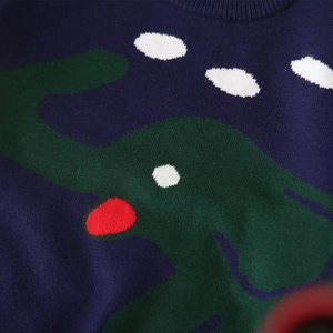 Detalle de jersey de punto azul marino con estampado de elefante verde y cuello acanalado