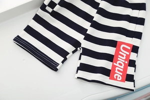 Detailed view of striped cotton shorts with a unique red rectangular fabric label